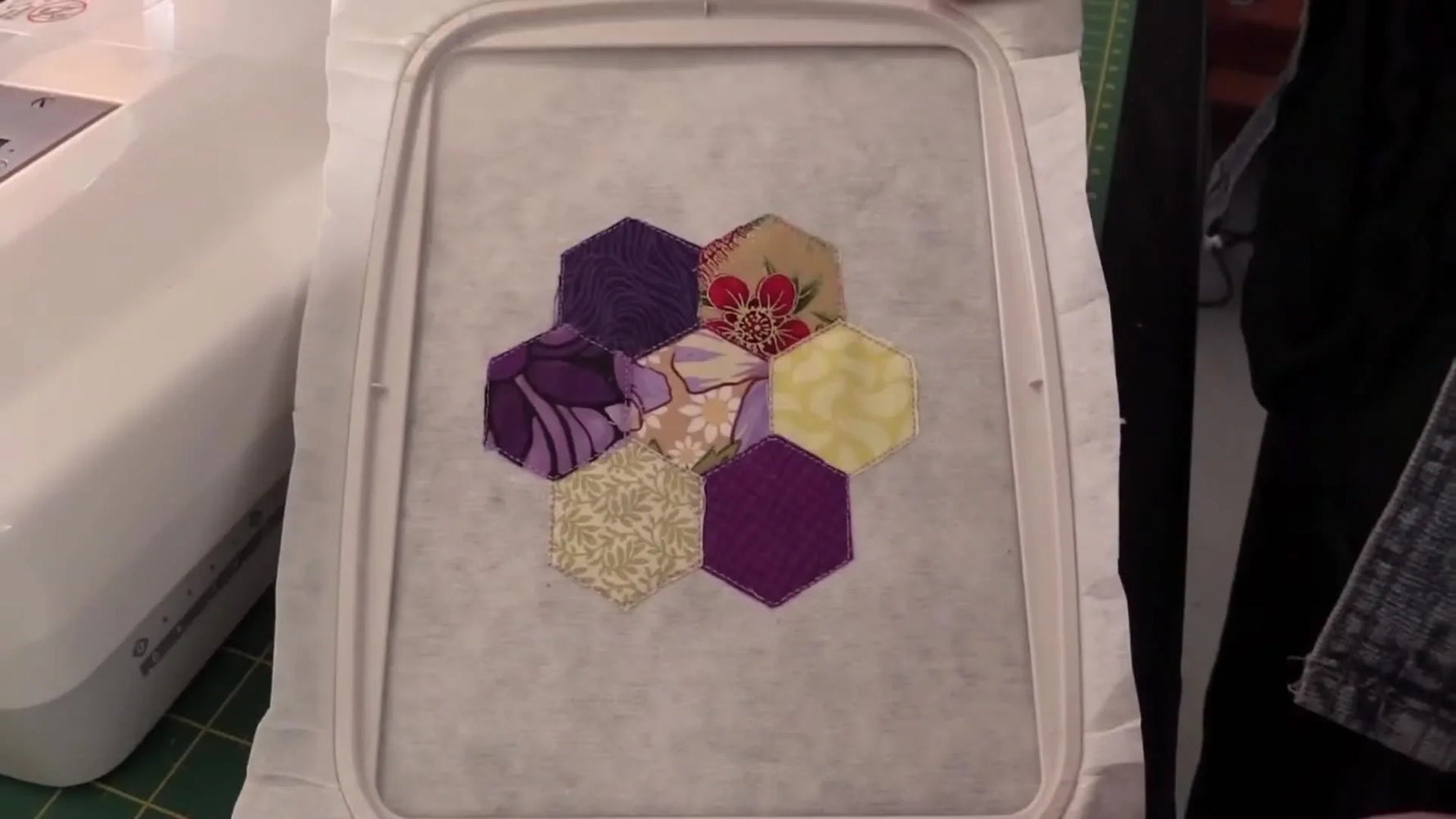 A fully filled honeycomb appliqué coaster design sits in the hoop, neatly trimmed and ready for the final decorative and satin border stitching.