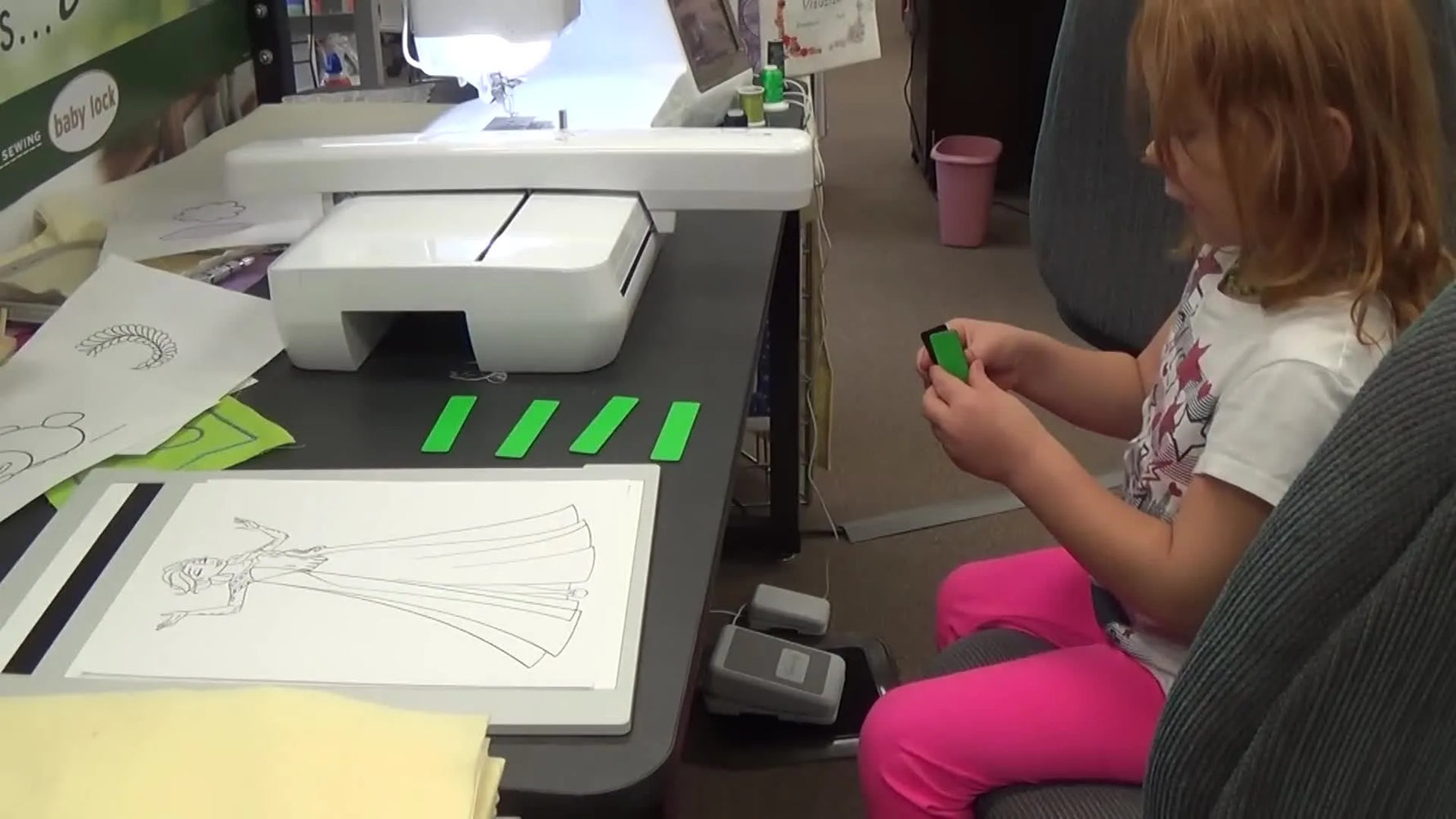 A close-up shows green magnets snapping onto the Baby Lock Scanning Frame to hold a coloring book page perfectly flat for scanning.