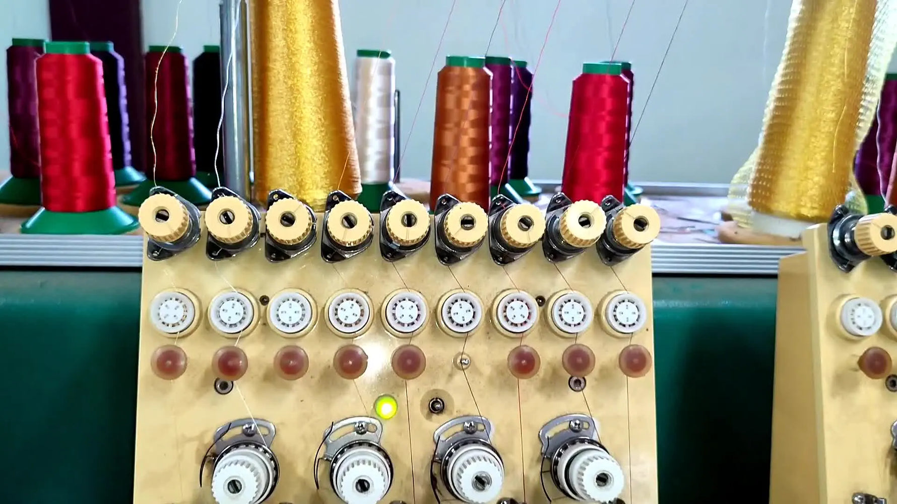 Top view of a computer embroidery machine with multiple spools of colorful thread.