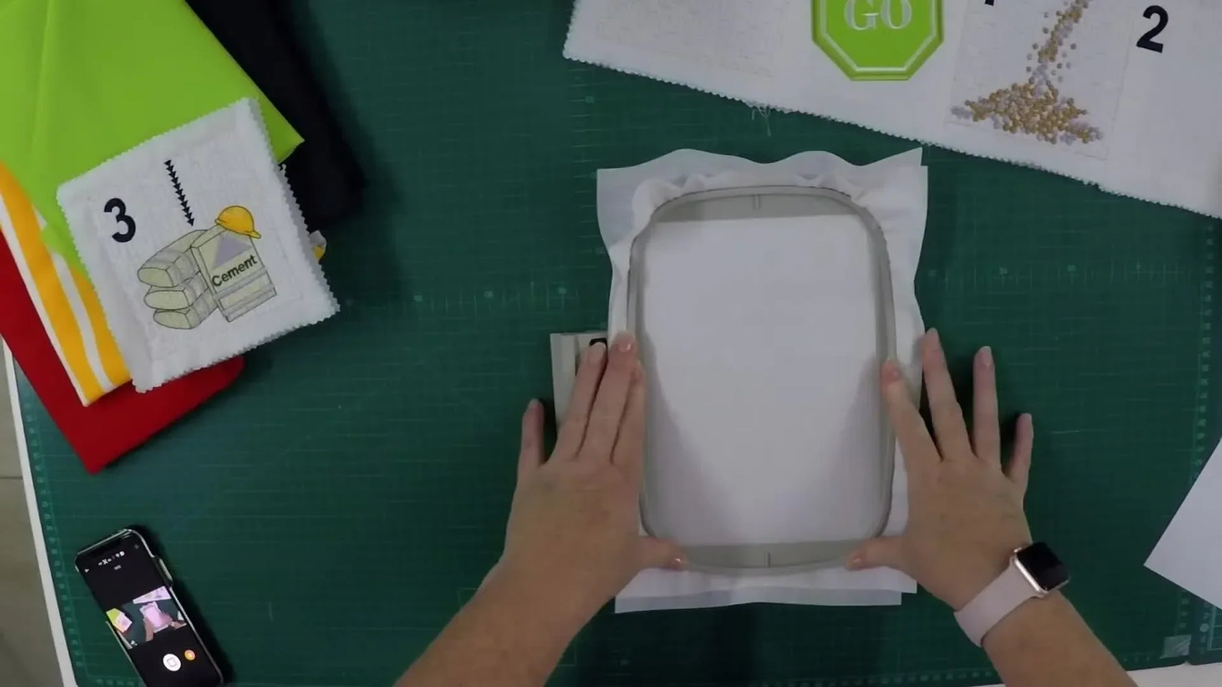 Completed 'GO' block removed from hoop with trimming in progress.