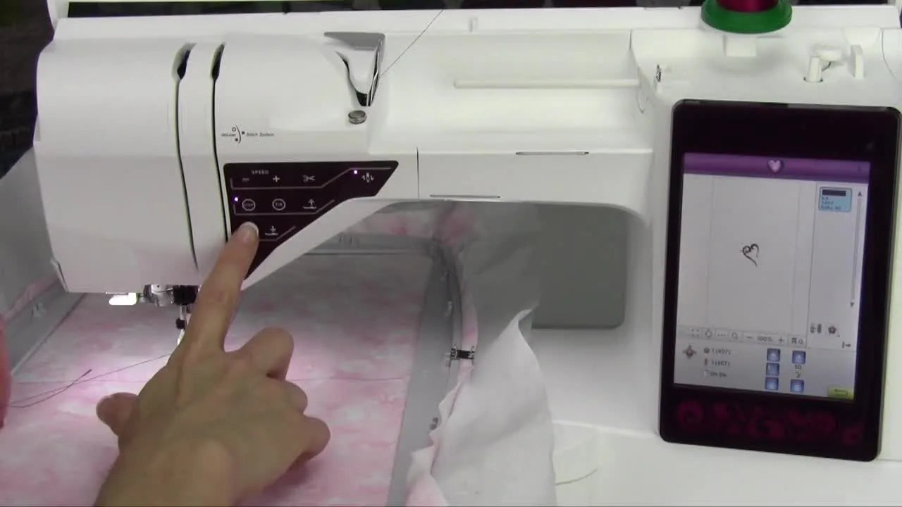 Hand holding top thread as machine starts embroidering