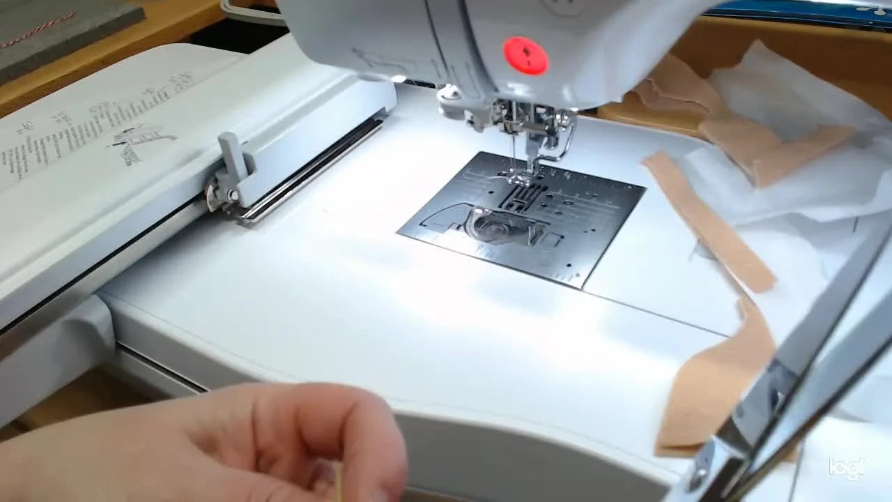 Close-up of curved embroidery scissors trimming only the front felt layer while the ribbon loop is pinned safely out of the cutting path.