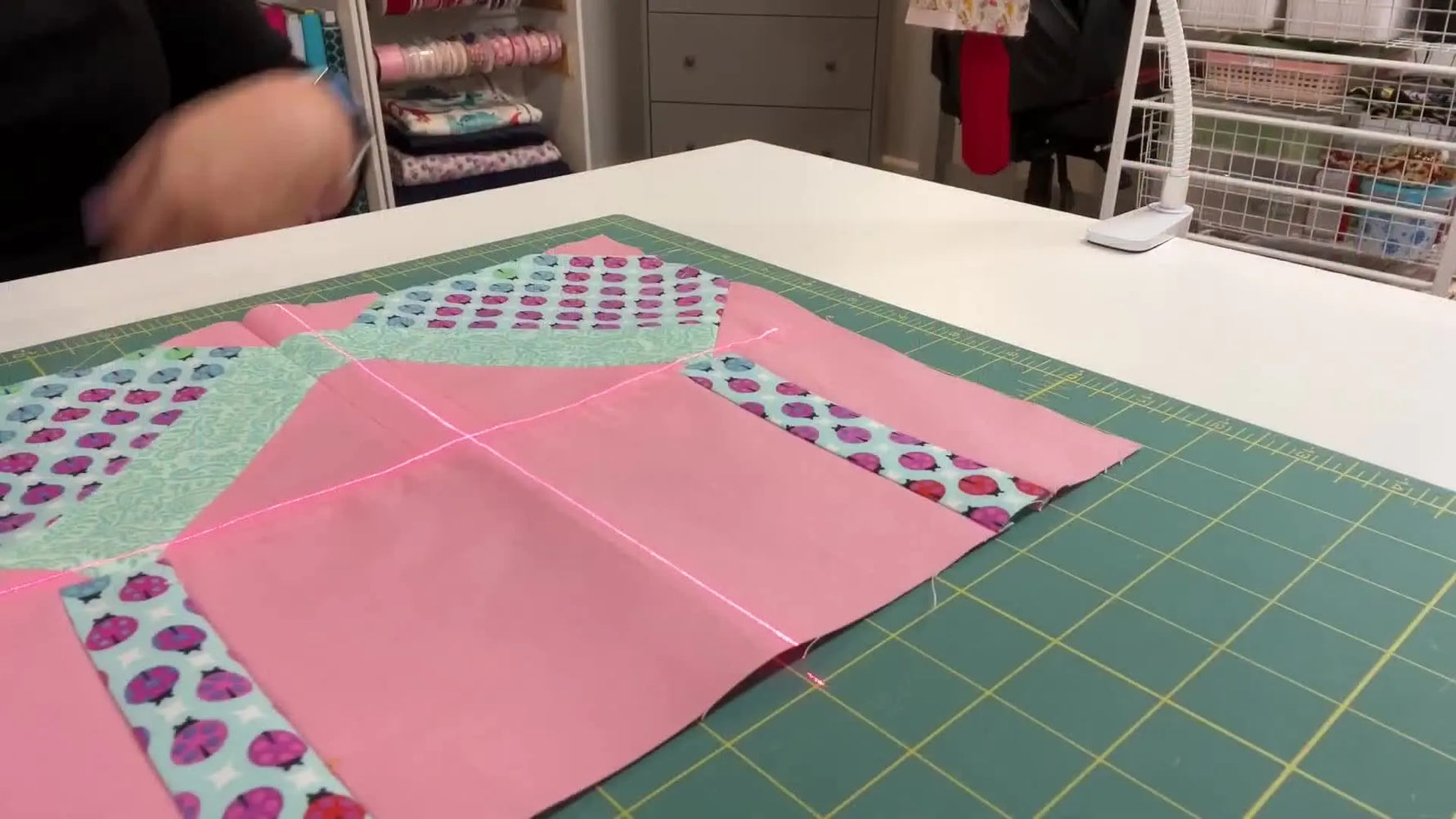 Red laser crosshairs projected onto a green cutting mat to establish a precise center point for alignment.