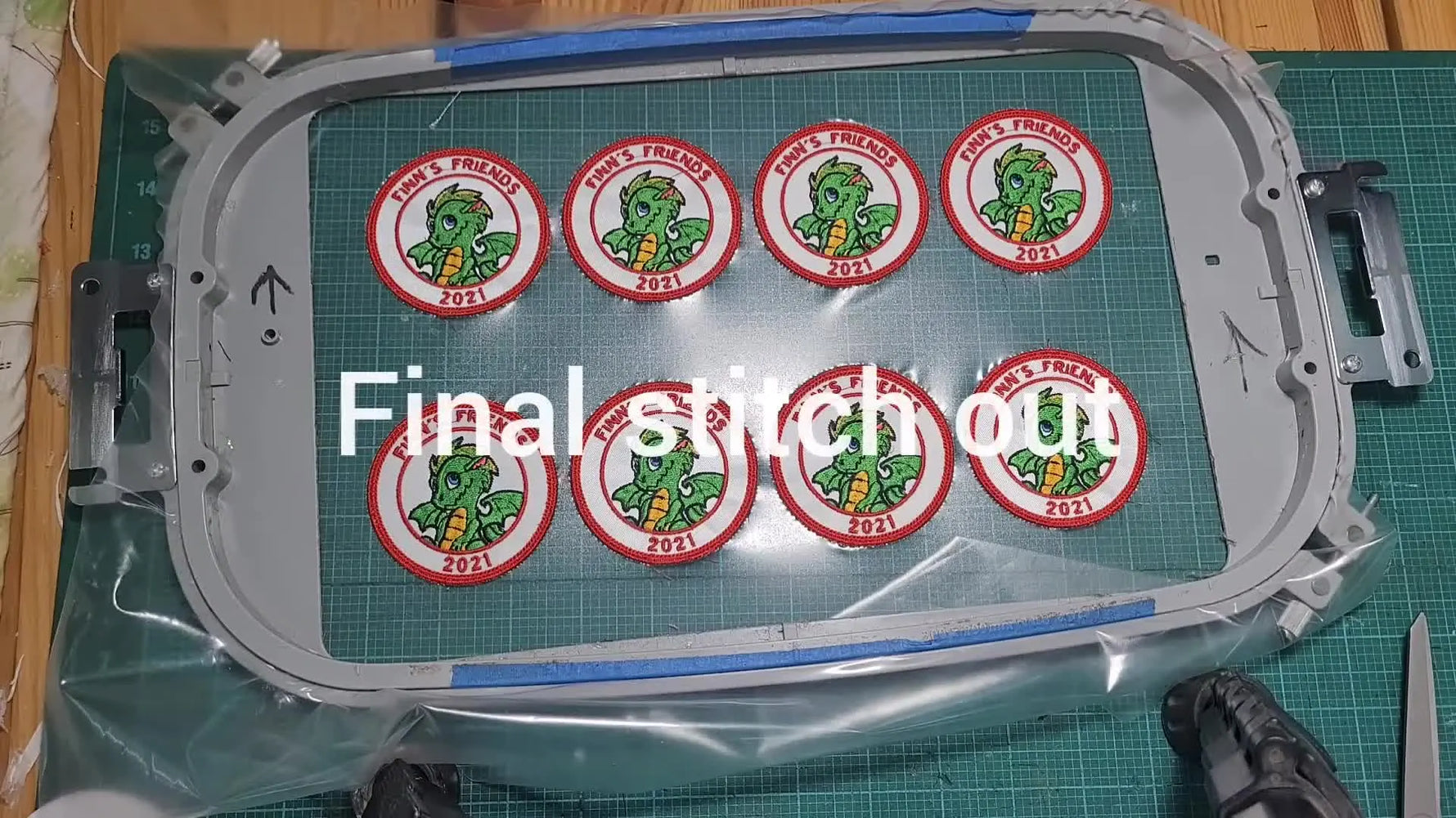 A large hoop filled with eight finished dragon patches stitched out in a clean production layout.