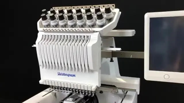 A fully set-up Meistergram PR 1500 on its stand with the screen and thread stand visible, ready for initial setup.
