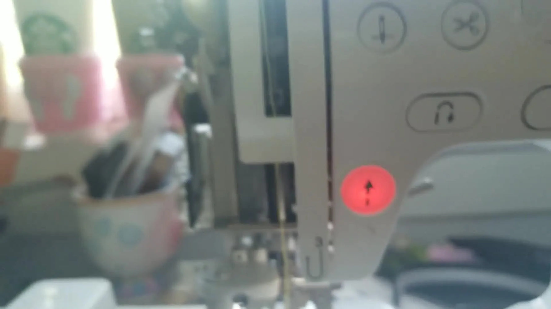 Close-up of precision scissors reaching into the Brother machine head to remove packed lint near the internal thread sensor hook.