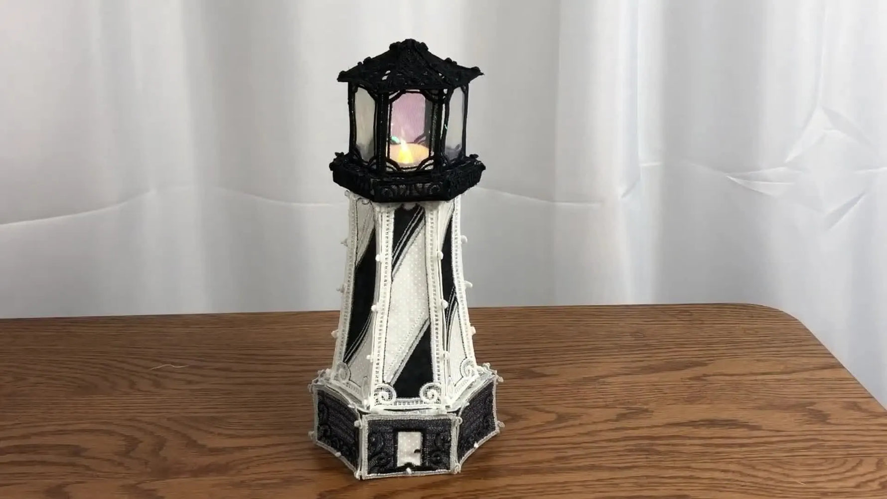 A completed 3D freestanding lace lighthouse with a tea light inside, showing the crisp structure FSL can achieve when stabilized and finished correctly.