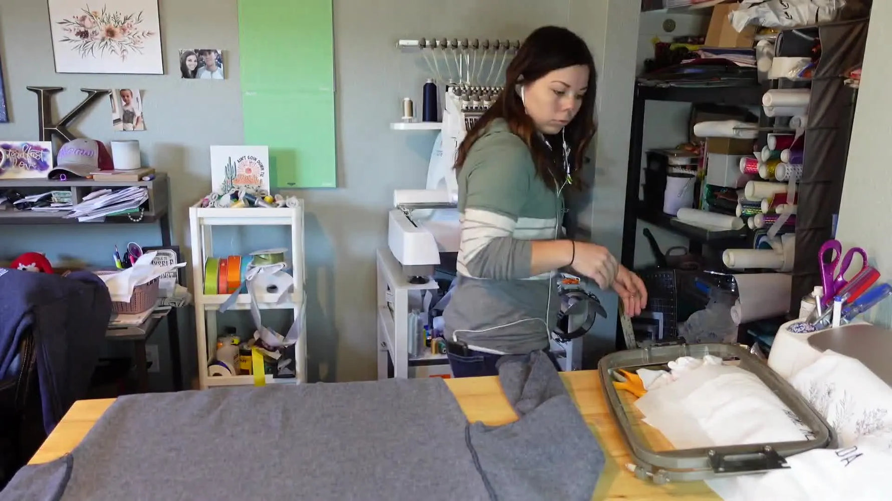 Woman preparing a grey sweatshirt for embroidery, laying down stabilizer.