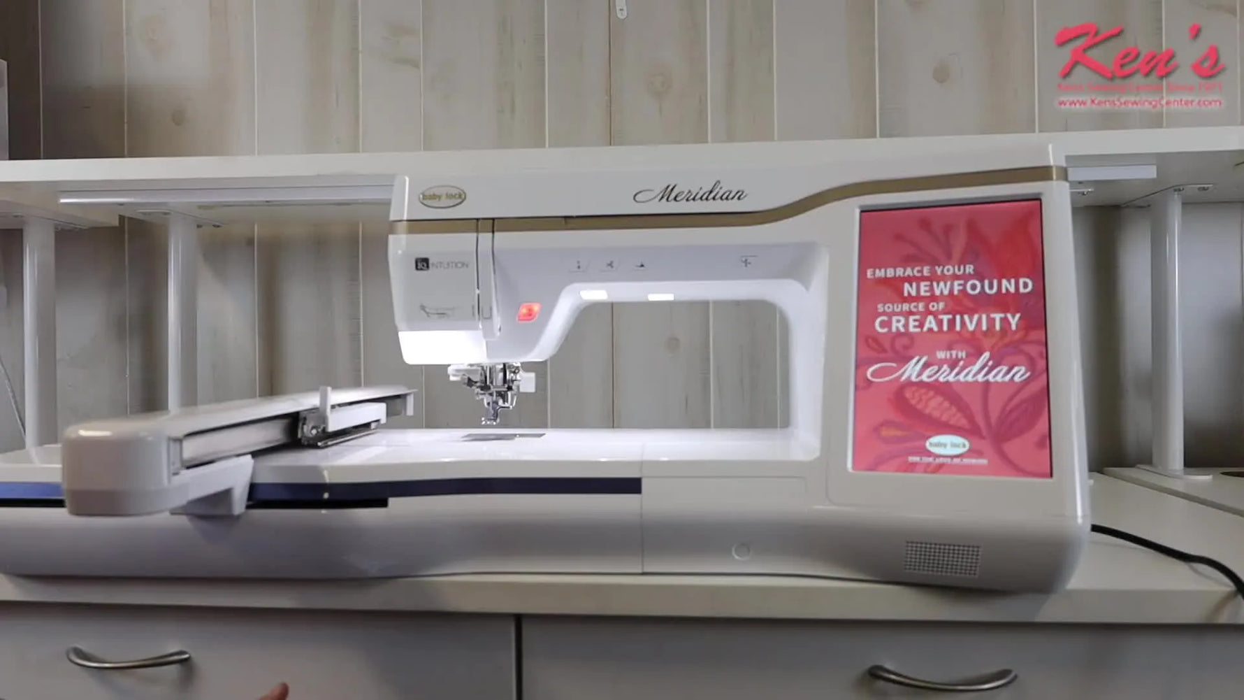 A wide shot of the Baby Lock Meridian with the embroidery unit attached, ready for large-hoop stitching on a clean work surface.