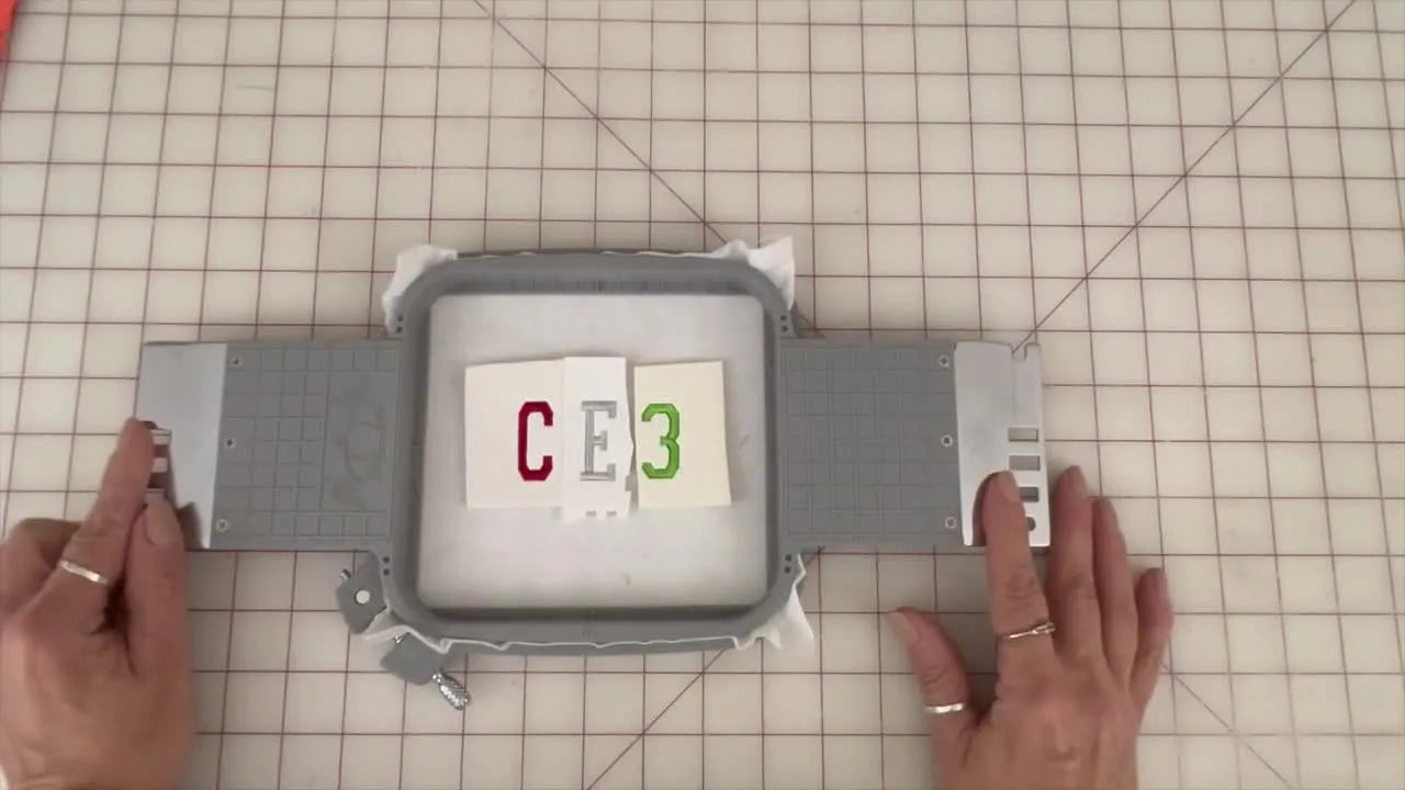 A CE3 stitch-out sample sits in an Allied hoop with labeled foam pieces still attached, ready for a side-by-side tear-away comparison.