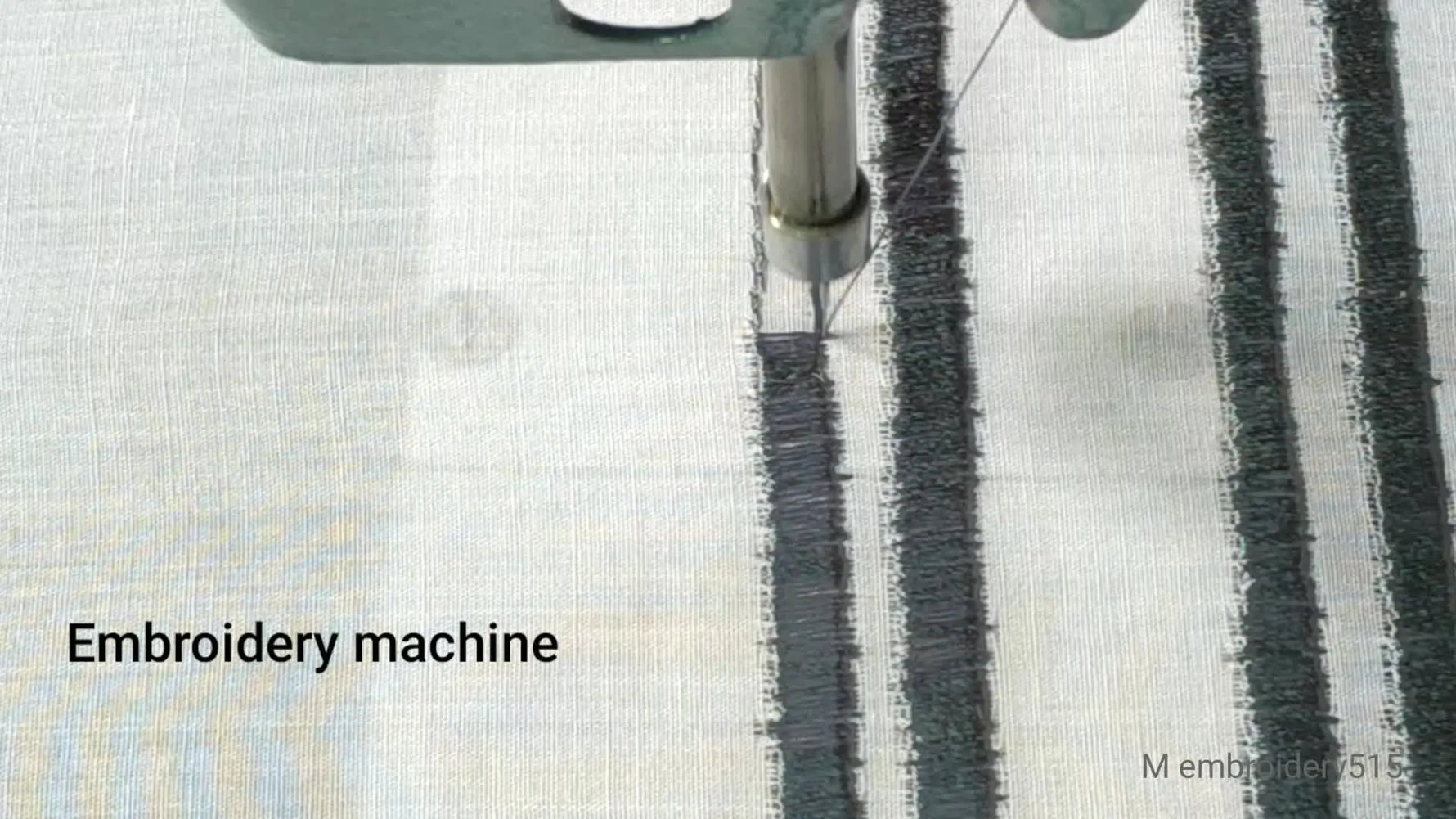 Close-up of embroidery machine needle making straight stitches on fabric.