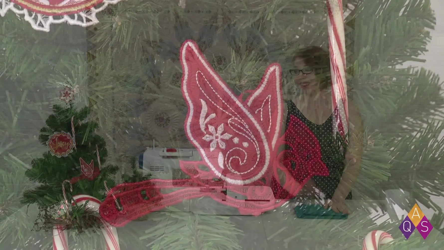 A finished red cardinal free-standing lace ornament hangs on a Christmas tree, showing crisp edges and a clean lace finish.