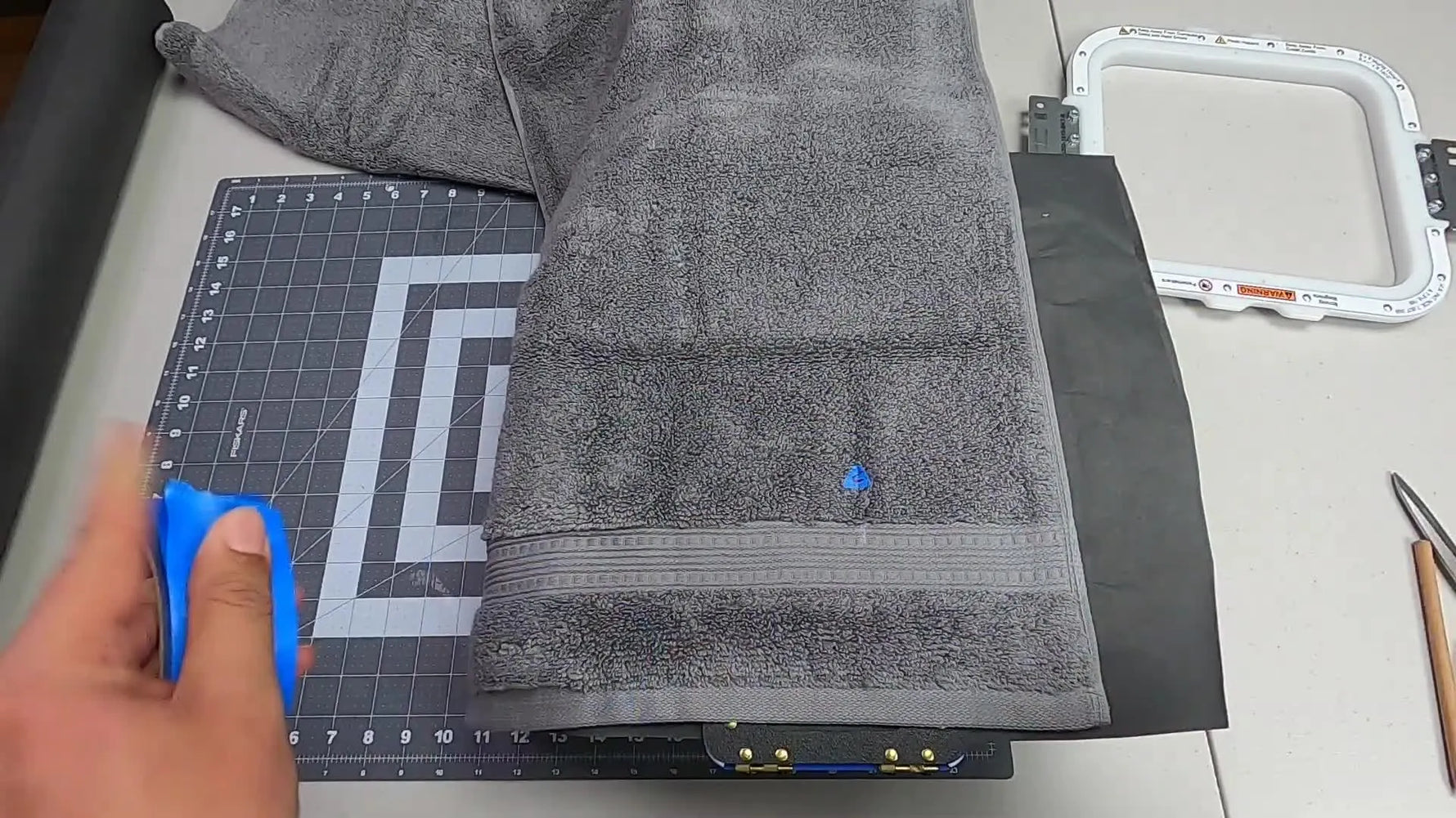 A plush towel is clamped firmly in an 8x9 magnetic hoop on a hooping station, ready for a clean, centered stitch-out.