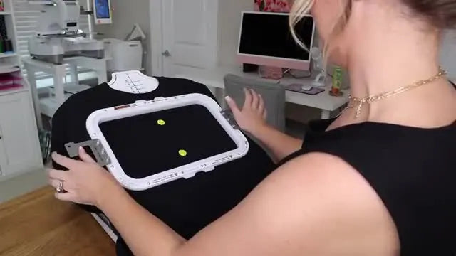 A magnetic hoop snaps down on a sweatshirt in a hooping station, capturing the fabric cleanly and evenly for a large center-chest stitch-out.