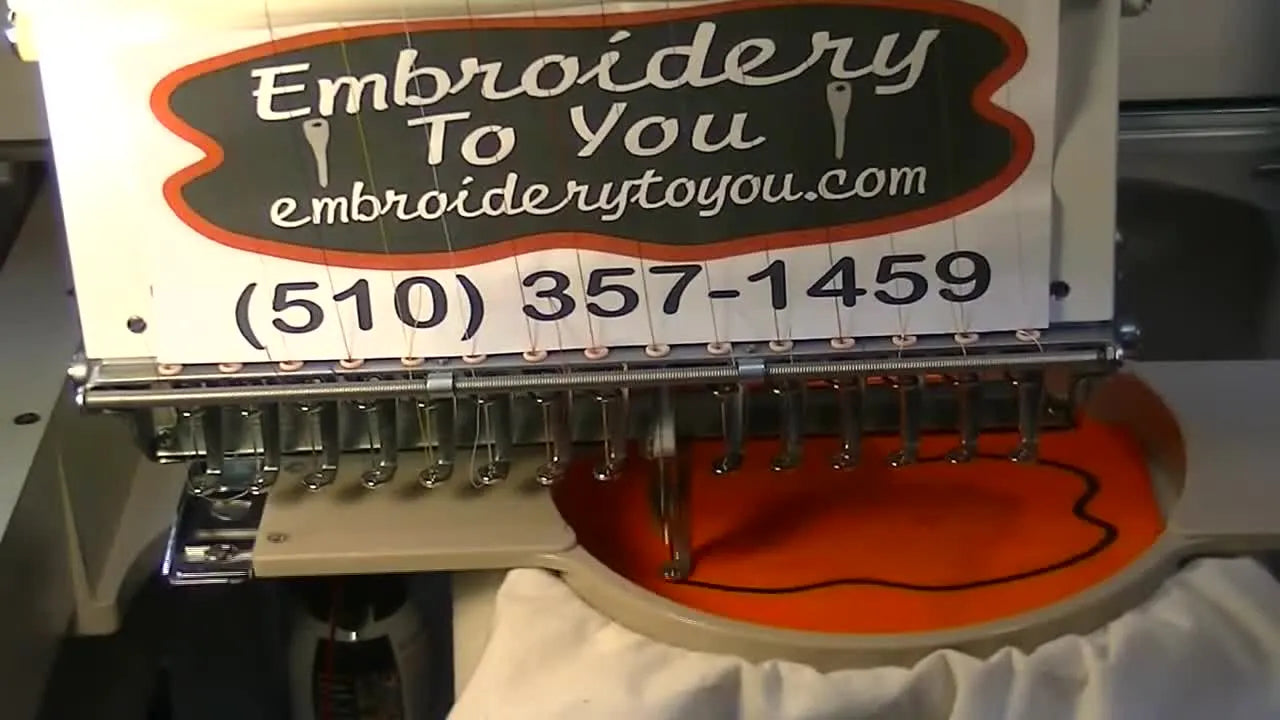 A close-up of an SWF multi-needle head stitching a bold satin border at high speed, showing the appliqué edge being formed cleanly.