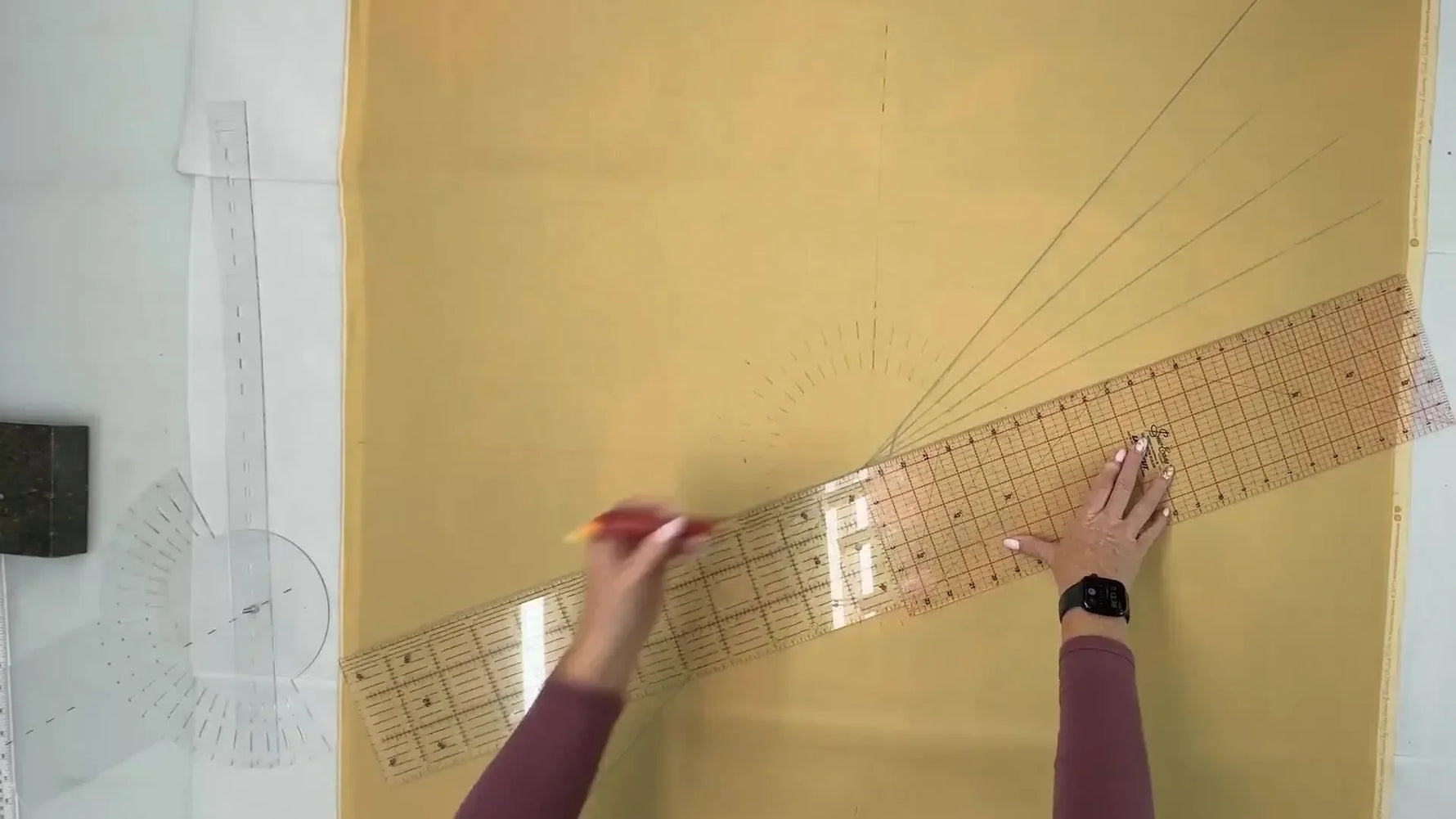 Top-down view of the fabric with a complex radial grid fully marked, ready for hooping.