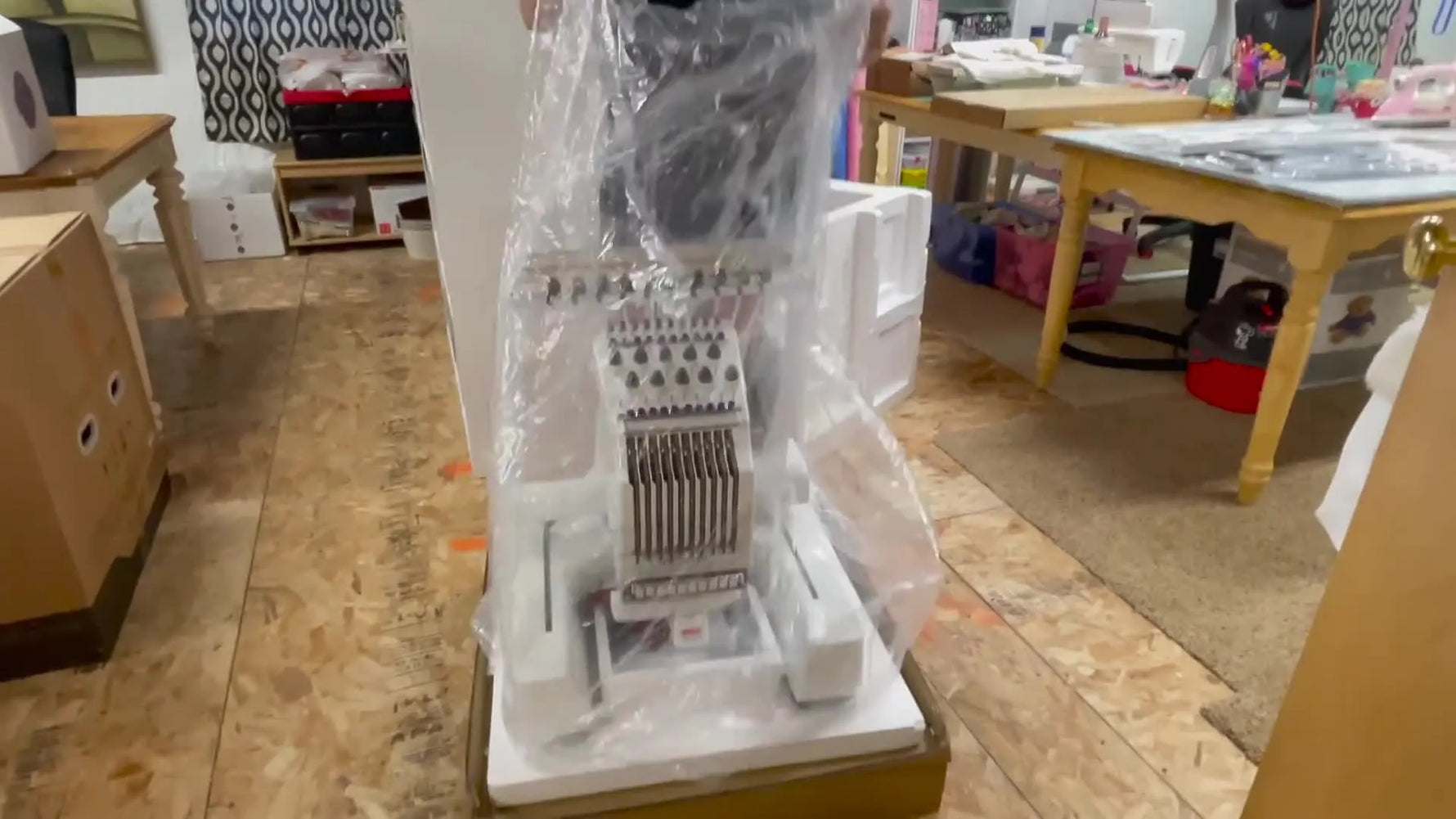 The Ricoma EM-1010 is fully unwrapped and revealed, showing the 10-needle head and overall machine footprint before setup begins.