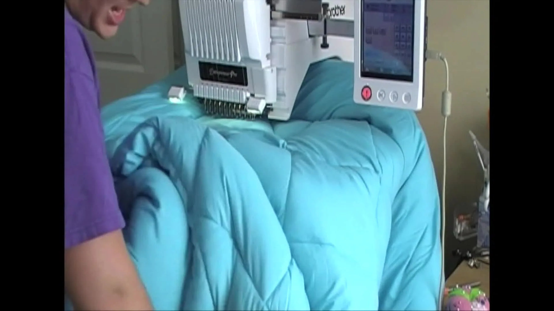 A wide shot shows the bulky comforter supported on an office chair beside the machine to prevent drag while the Jumbo Fast Frame is mounted.