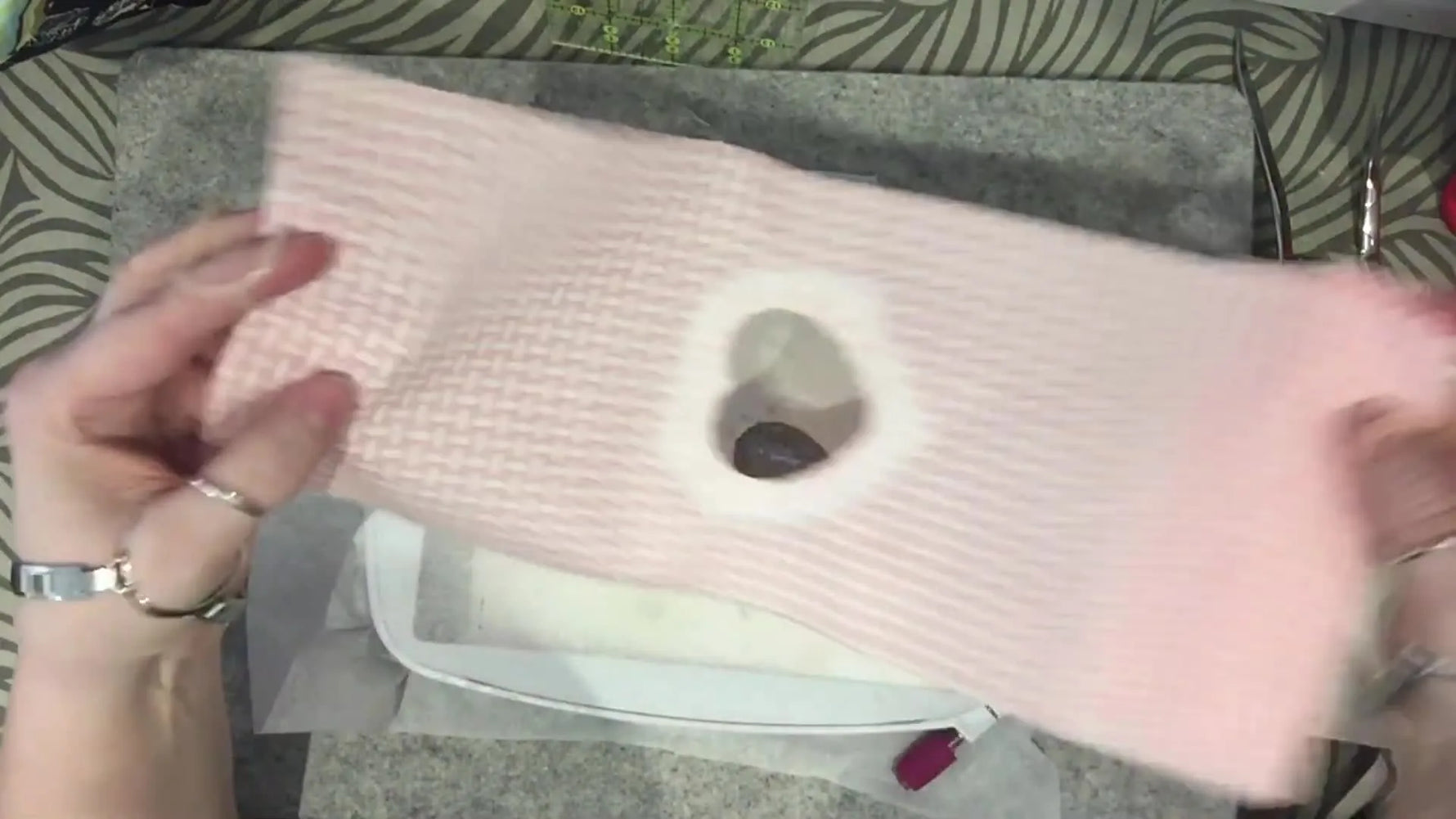 An overhead view shows the finished heart-window lining piece being aligned onto the exterior hoop so the window layers stitch together cleanly.