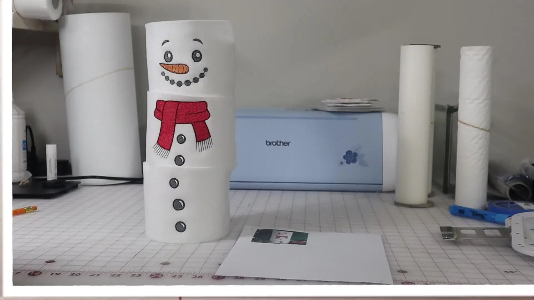 A finished three-roll snowman stack with embroidered felt sleeves, shown as a complete holiday bathroom decoration.