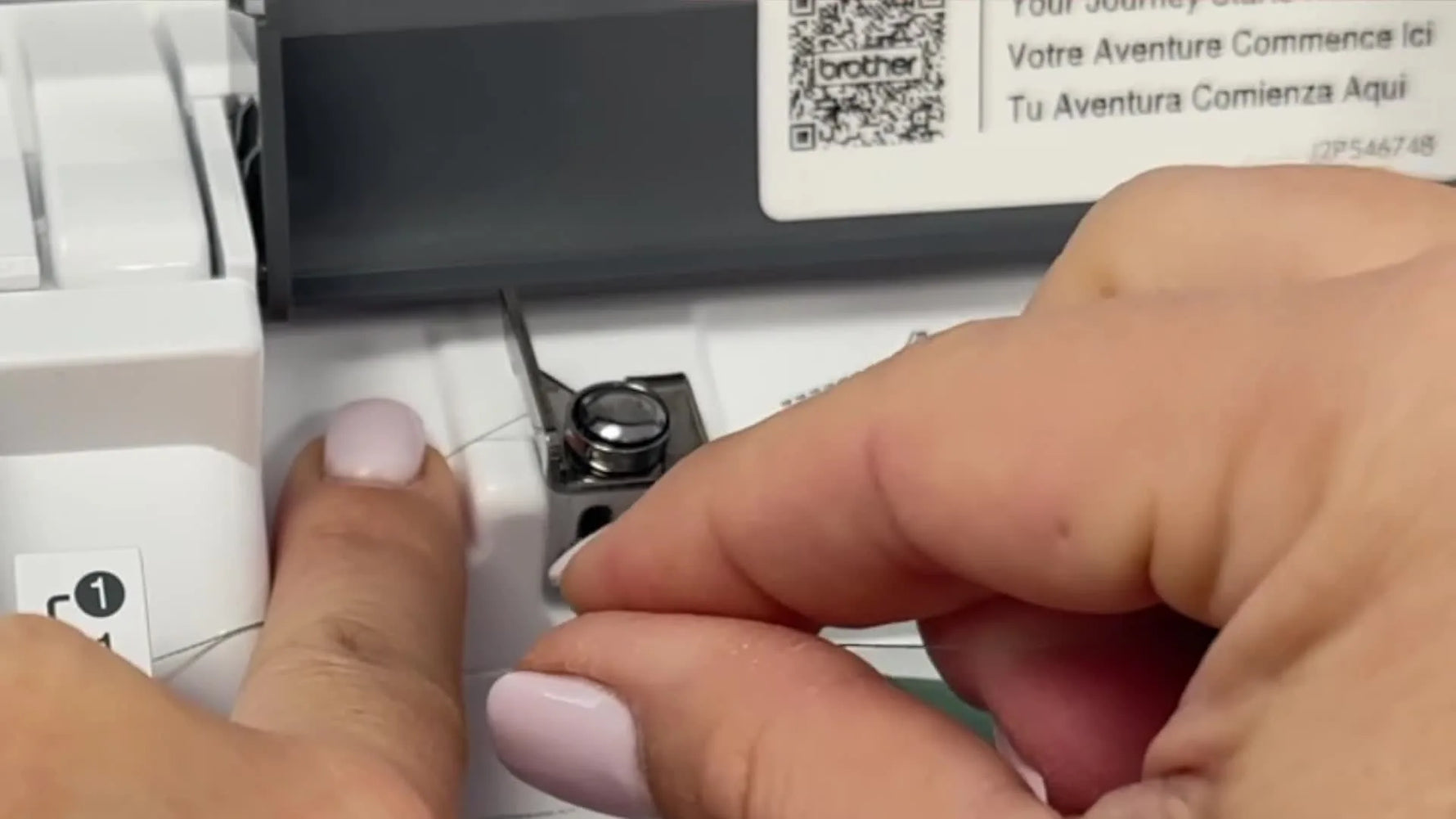 A close-up of the thread seated under the Brother machine’s metal pre-tension disc (Guide #3), the make-or-break point for smooth bobbin winding.
