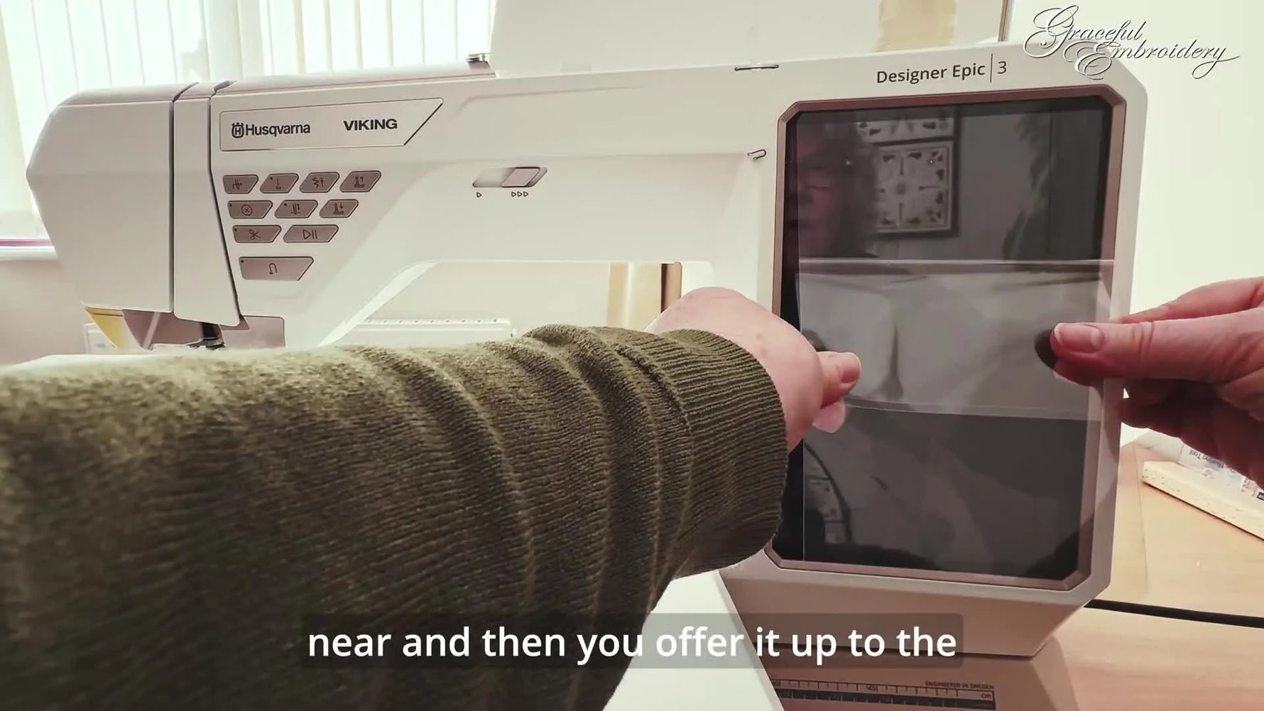 Close-up of aligning a screen protector on the Husqvarna Viking Designer Epic 3 touchscreen for a clean, centered fit.