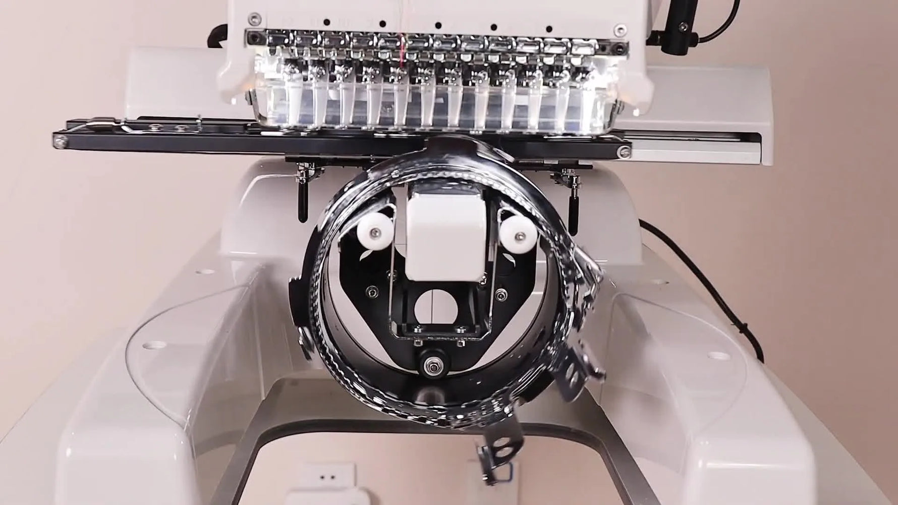 Front view of a fully installed Smartstitch cap driver mounted on the machine and ready to accept a hooped cap.