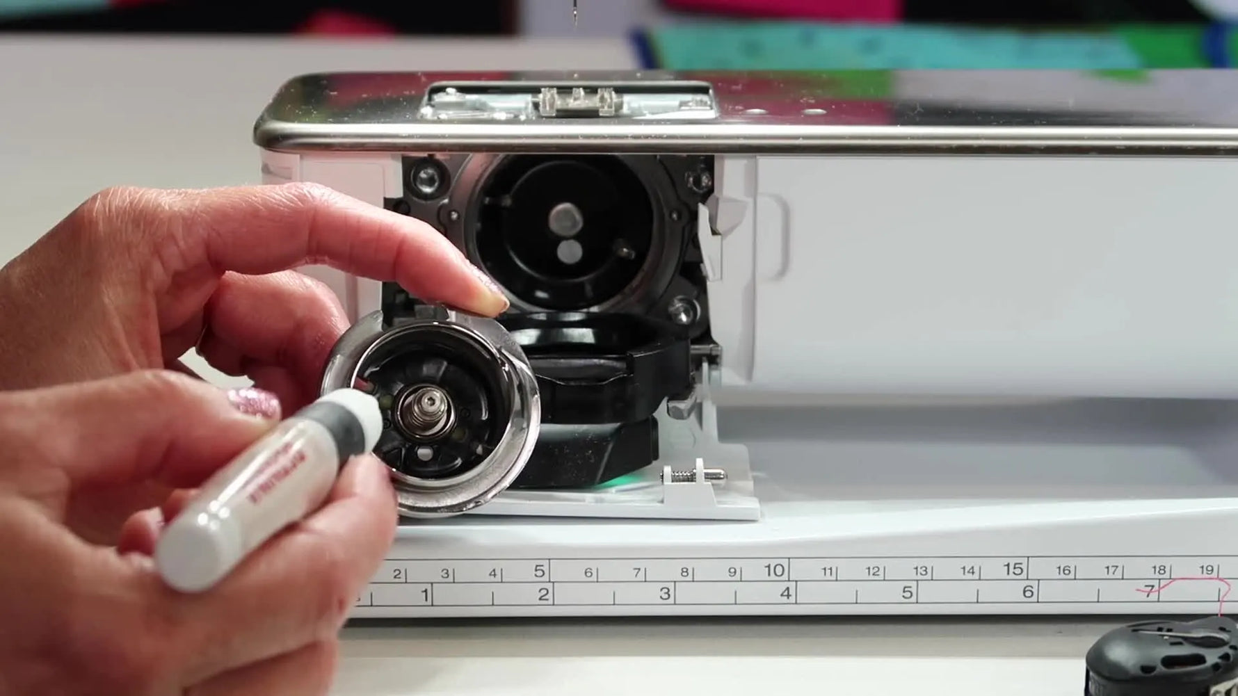 A close-up shows oil being applied to the two small yellow felt pads inside the Bernina 790 Plus magnetic hook—an easy-to-miss detail that prevents snags and thread breaks.