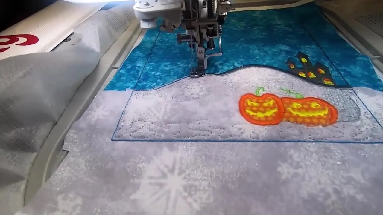 A wide view of the Halloween Town block while the large black spooky tree is stitching across the layered sky and ground appliqué.