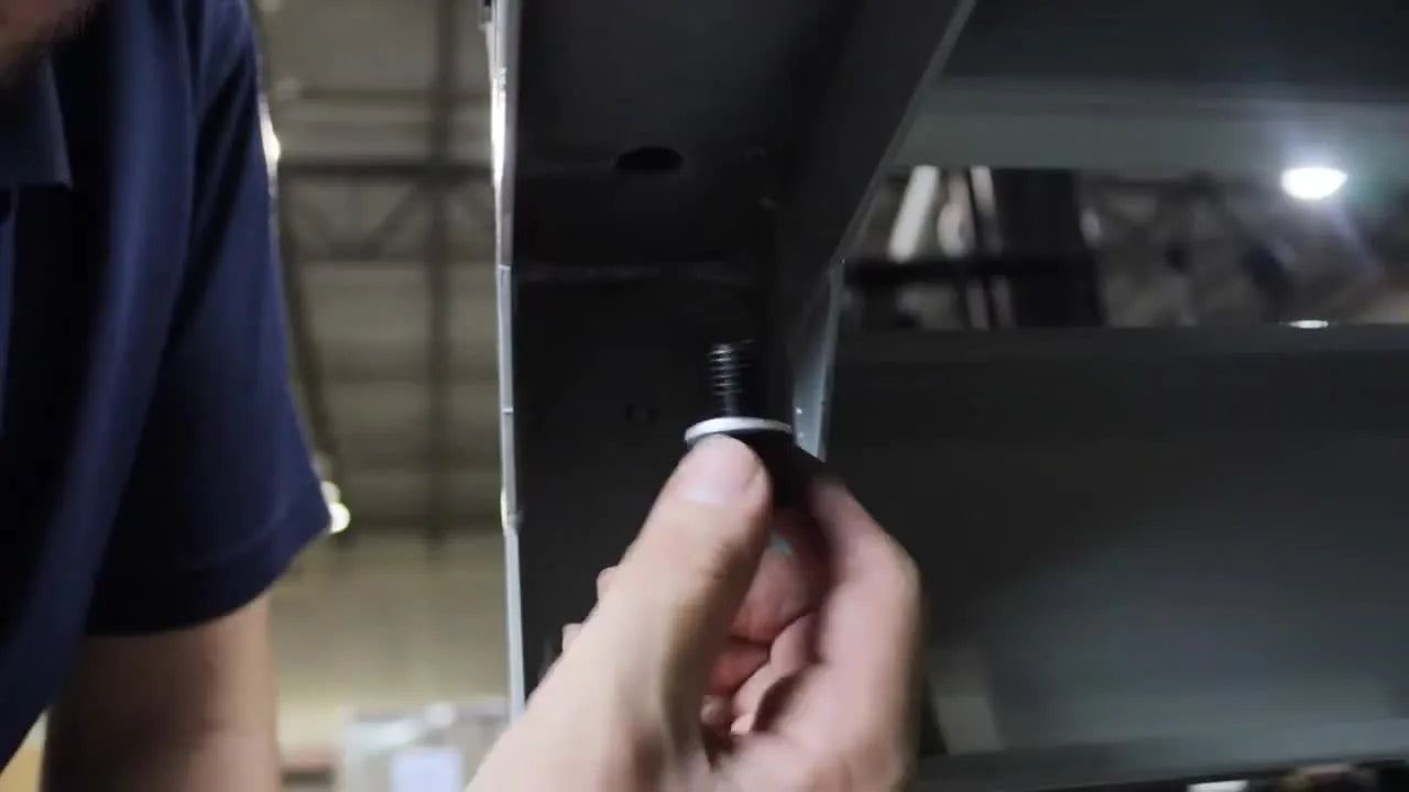 A technician inserts the mounting bolt from underneath the stand to secure the Meistergram GEM 1502 TC base through the rubber grommet.