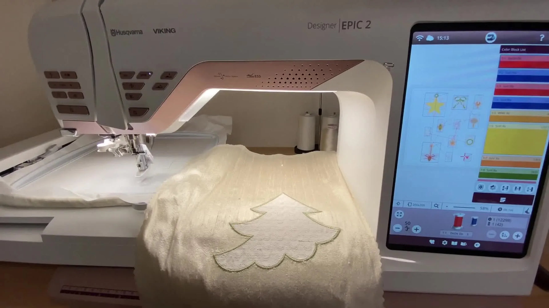 A Husqvarna Viking Designer EPIC 2 sits ready with a crazy quilt block draped over the bed, setting up for precise stitch-and-remove ornament placement.