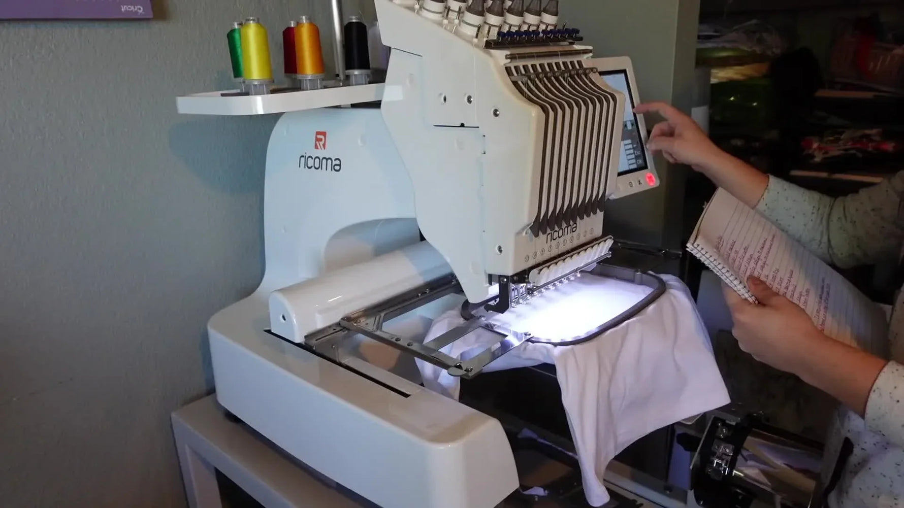 Using the Ricoma EM-1010 touchscreen with handwritten setup notes.