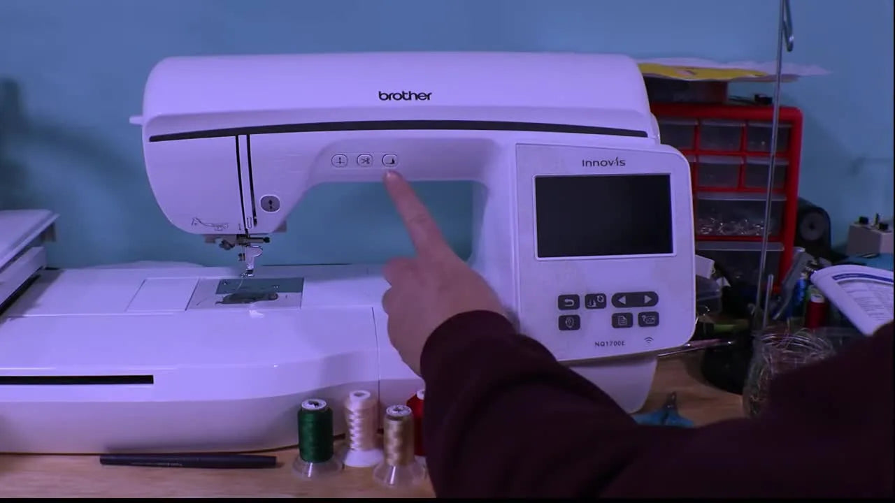 A close-up shows the exact presser-foot button hold while switching power on to enter Brother NQ1700E update mode.