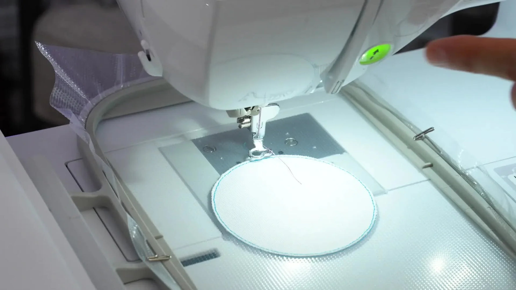 A close-up of the machine stitching a thick faux merrow border around a patch on clear Prep Patch film.