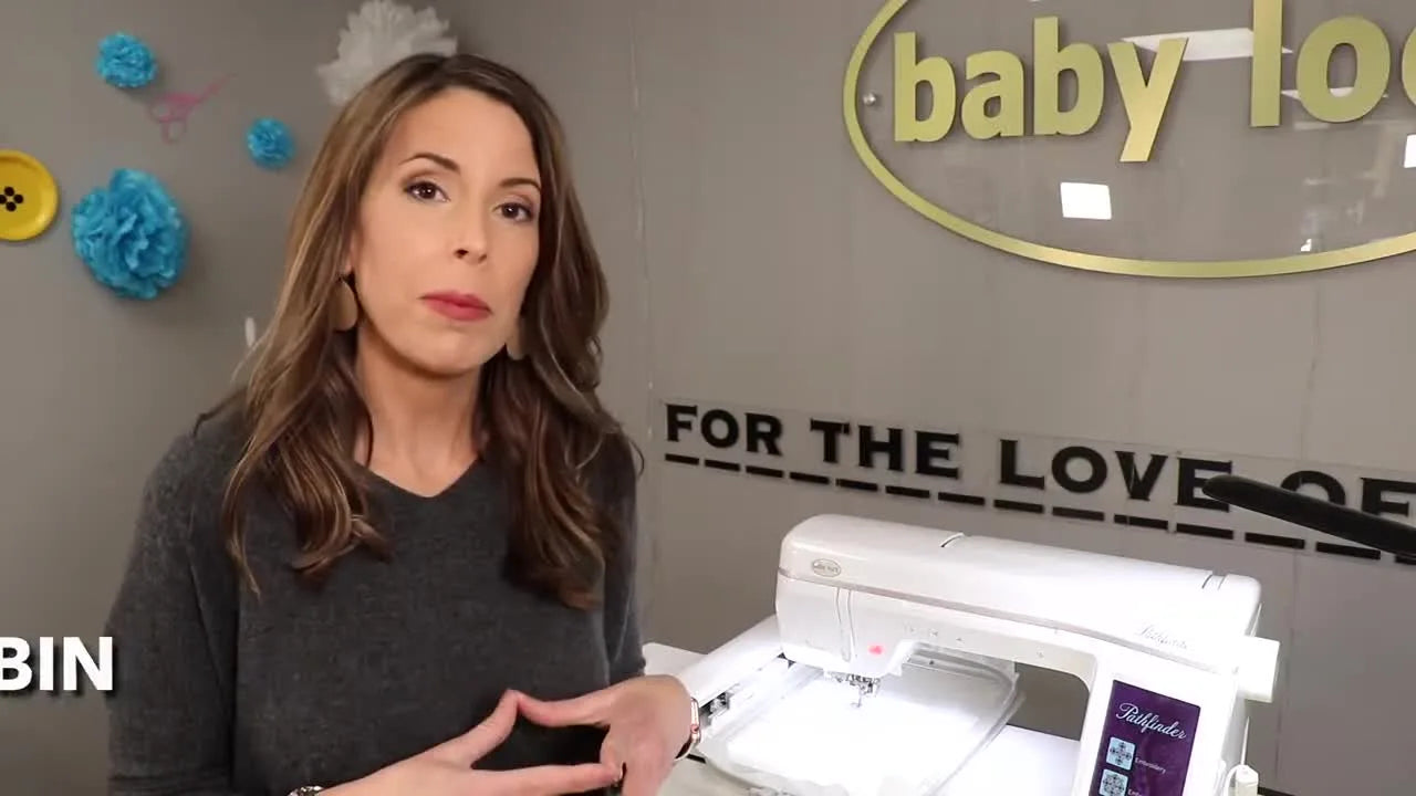 A Baby Lock Pathfinder embroidery machine sits on a work table with the large hoop attached, ready for a ribbon embroidery placement demo.