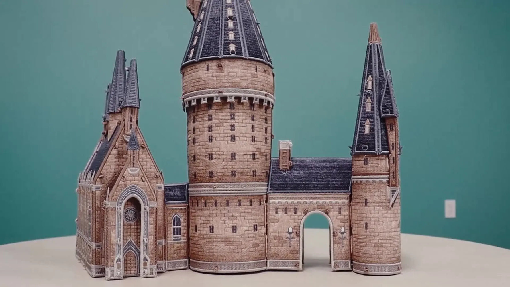 A completed freestanding embroidered Hogwarts castle displayed on a table, showing the final 3D structure you’re building toward.