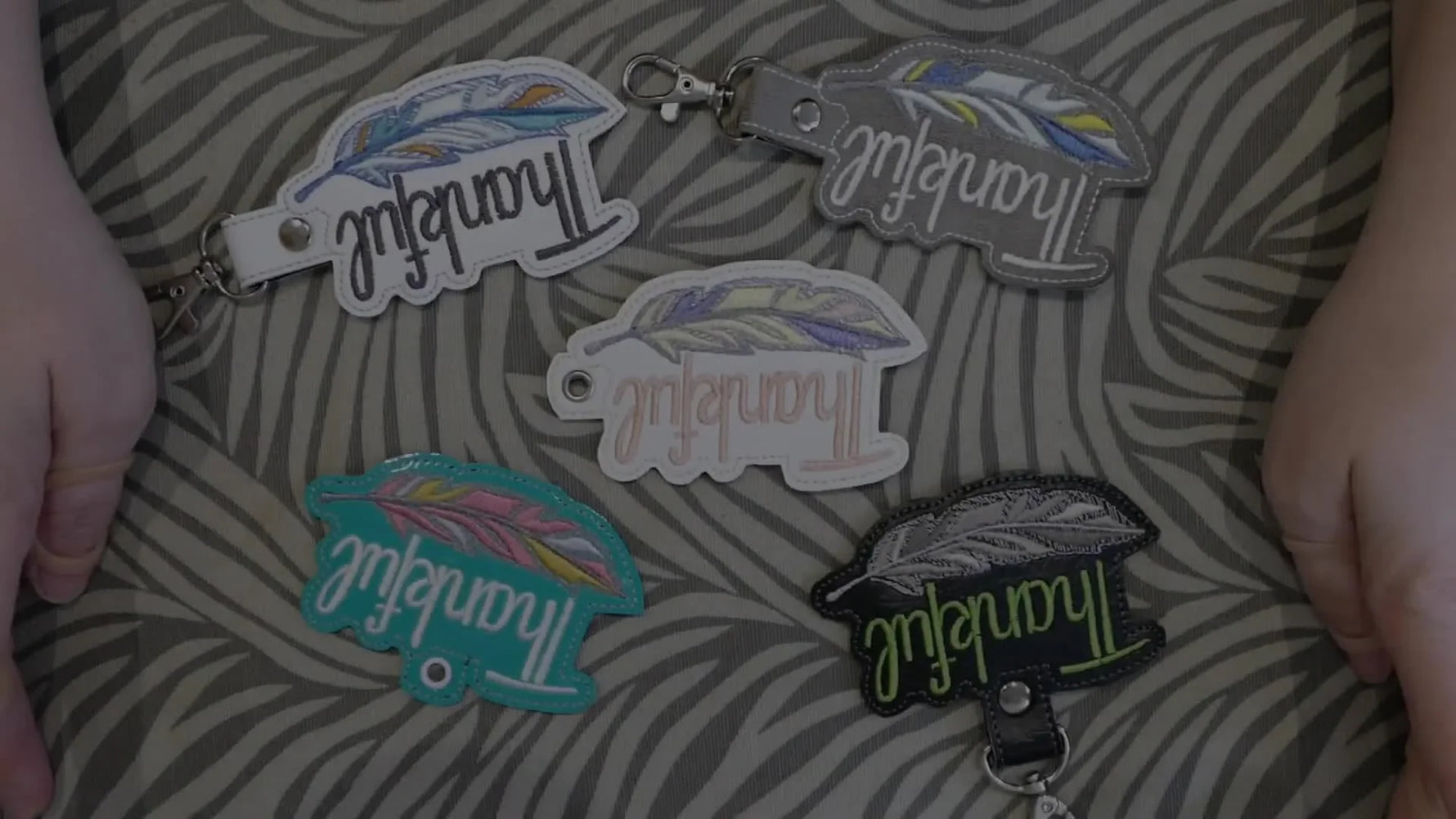 A neat spread of finished vinyl snap tab keychains showing clean bean-stitch borders and professional hardware.