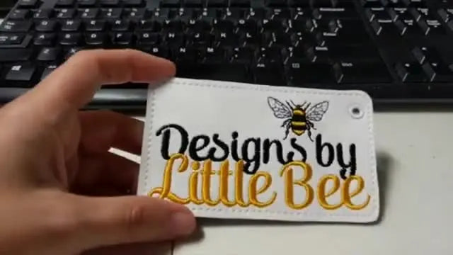 A close-up of a finished embroidered vinyl badge holder showing crisp lettering and solid coverage.