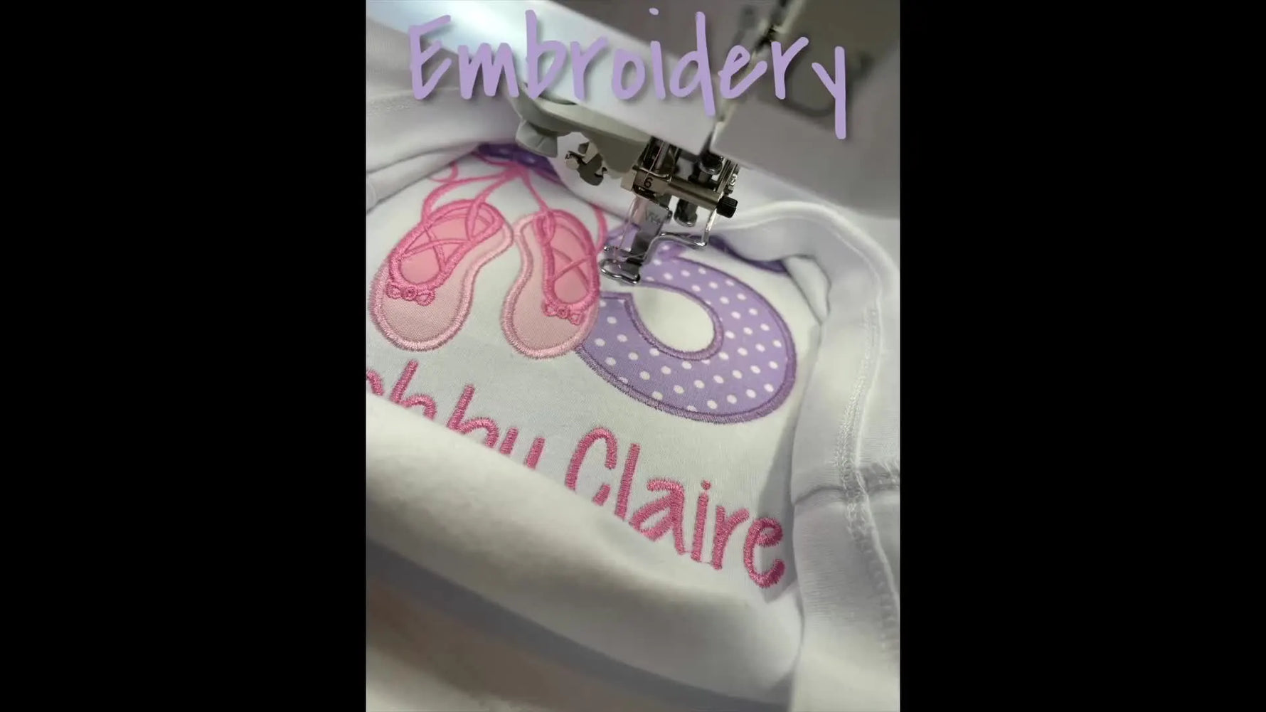 Embroidery machine stitching ballet slippers and the number 6 on a white baby onesie with 'Abby Claire' text.