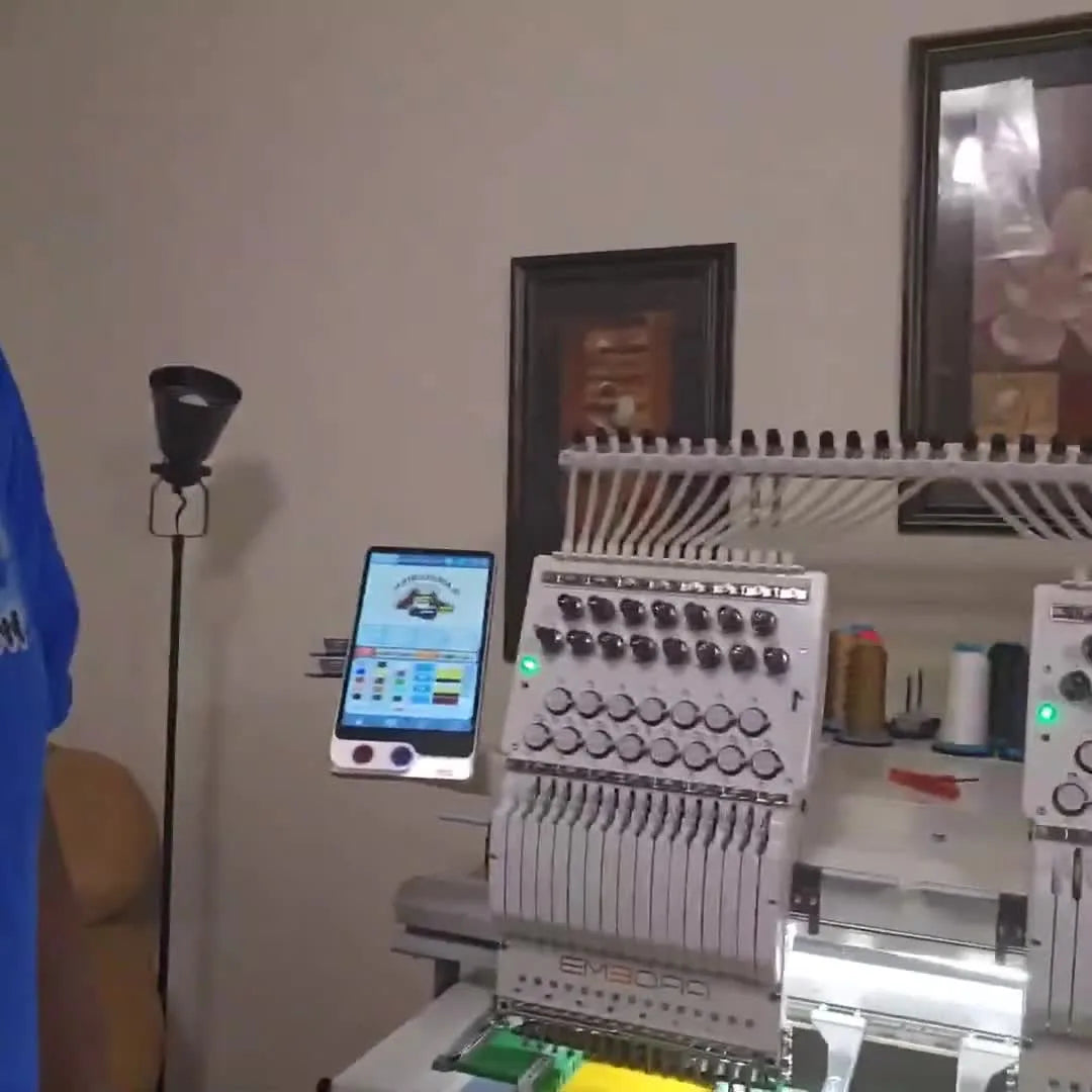 A wide view of the Pro M FW-1502 dual head machine set up with hooped yellow shirts, ready for a production run.