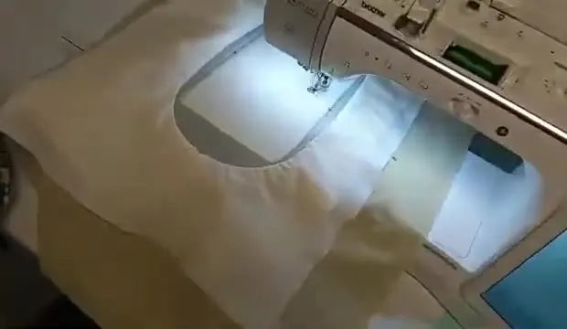 A close-up overhead view of the Brother Luminaire stitching the placement box on a hooped quilt sandwich.