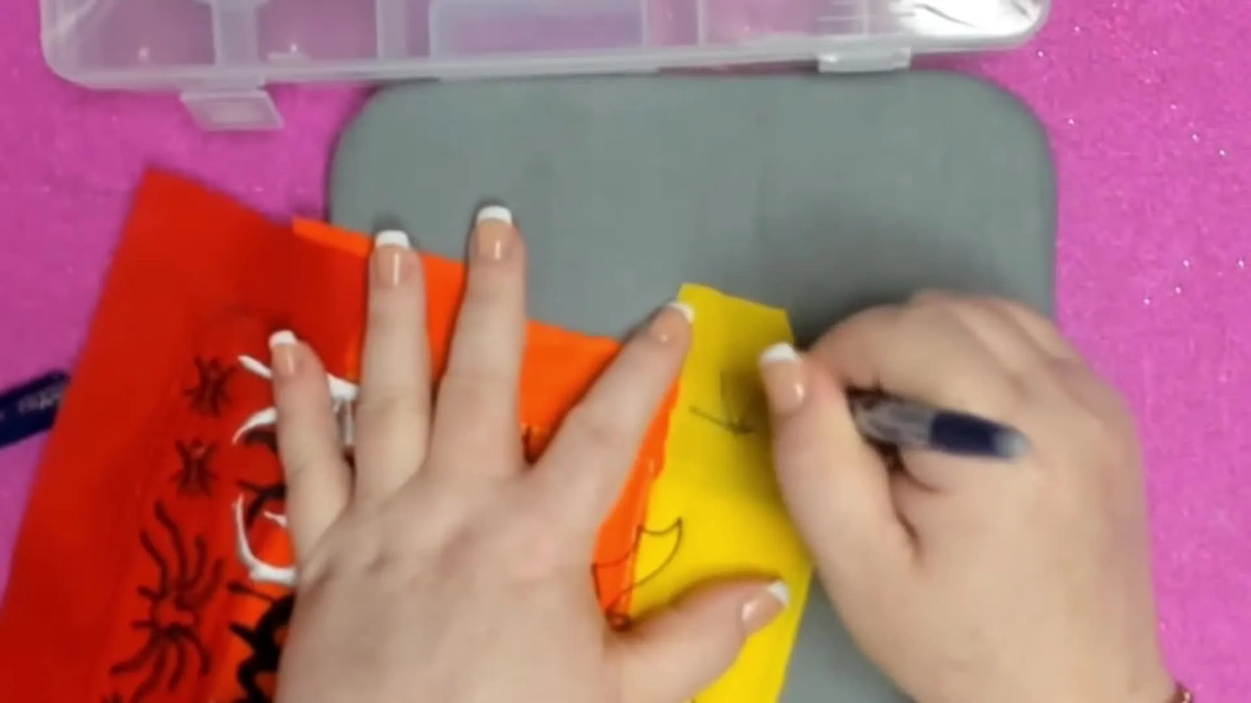 A mini heat press touches marked fabric and the blue ink disappears instantly, demonstrating heat-erasable placement marking.