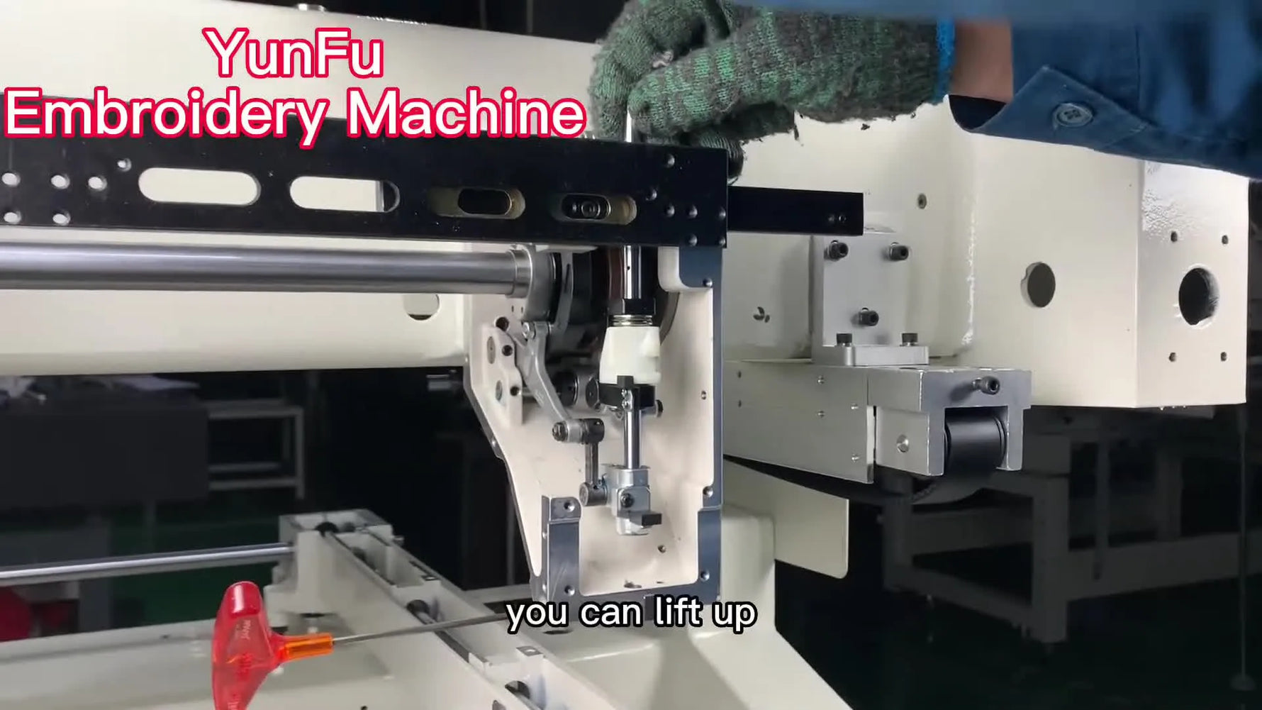 A technician lifts the reciprocating bar straight up out of the YunFu machine head to access and replace the broken drive slider.