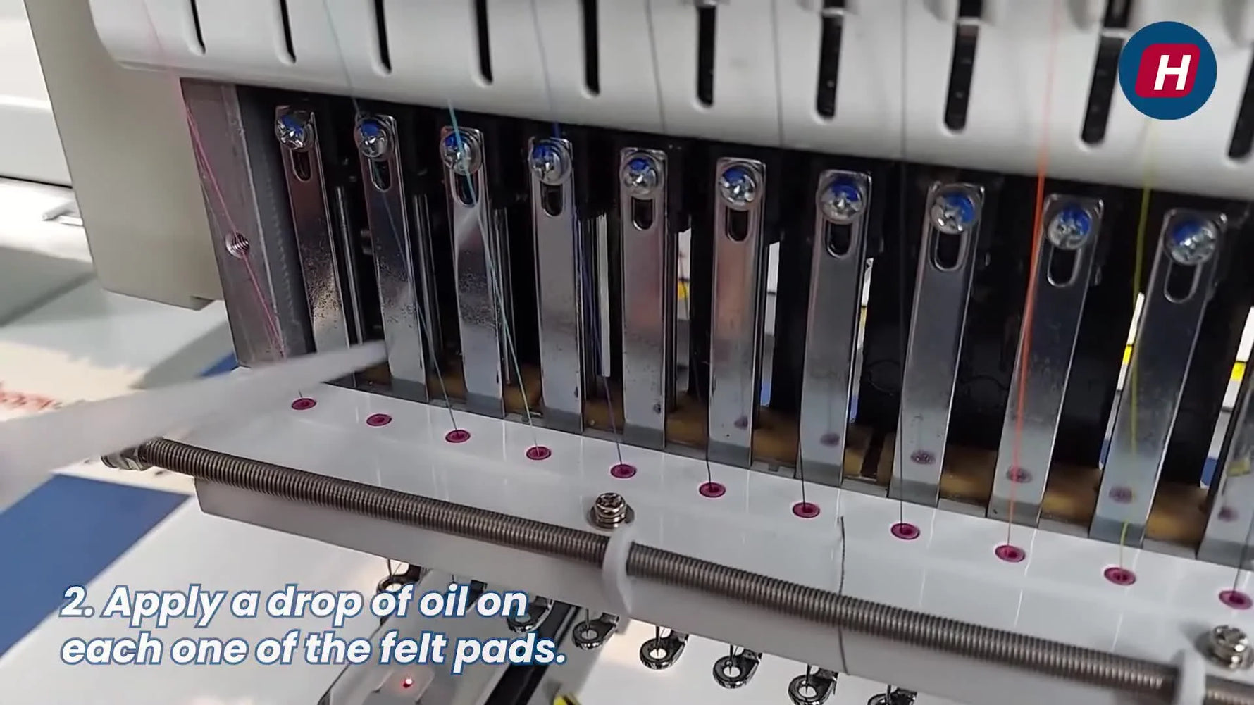A close-up shows oil being applied directly onto the felt pads behind the needle bars on a Happy Japan HCD3 head.