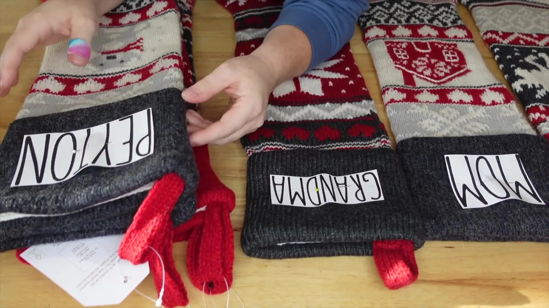 Close-up of several Pottery Barn Christmas stockings laid out, some with paper templates for names.