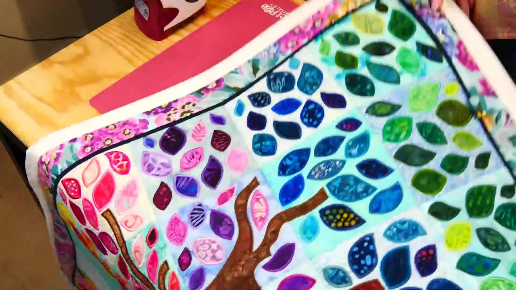 The finished Tree of Life wall hanging laid flat, showing the full tree motif and colorful leaf canopy.