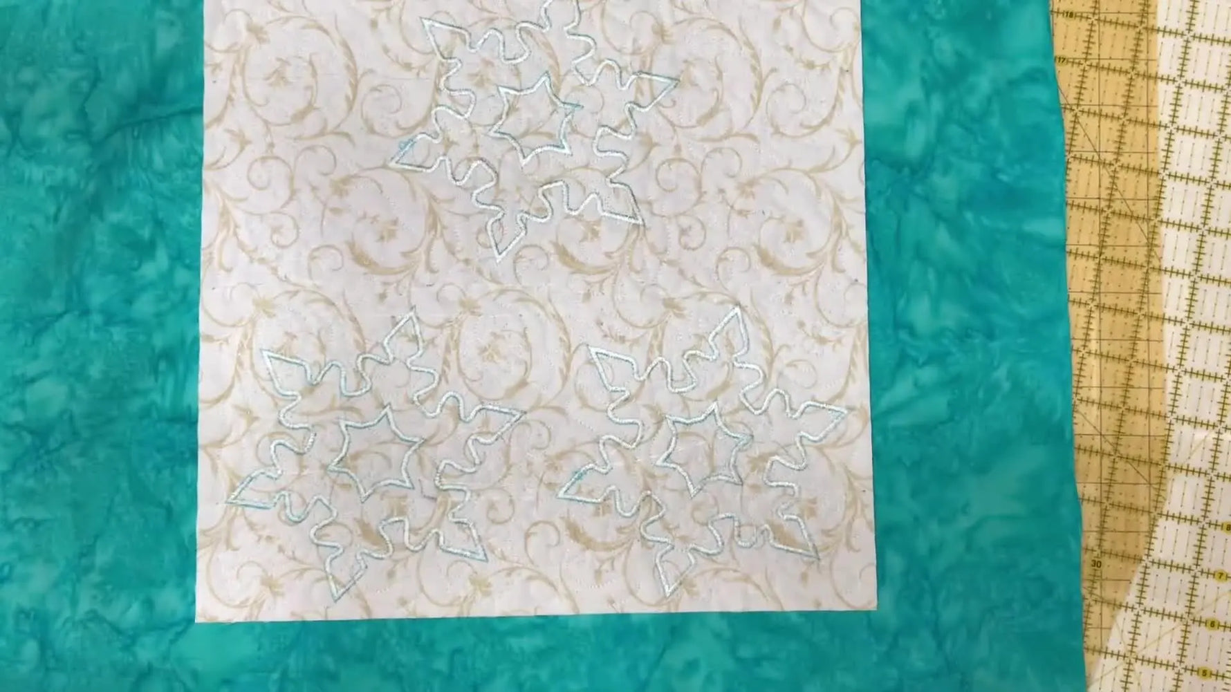 An overhead view showing the 1-inch backing allowance used to create a clean self-binding border around the quilted placemat.