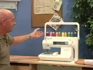 A close-up of the Hemingworth thread stand loaded with 10 colorful spools, showing the arched top guides and compact footprint.