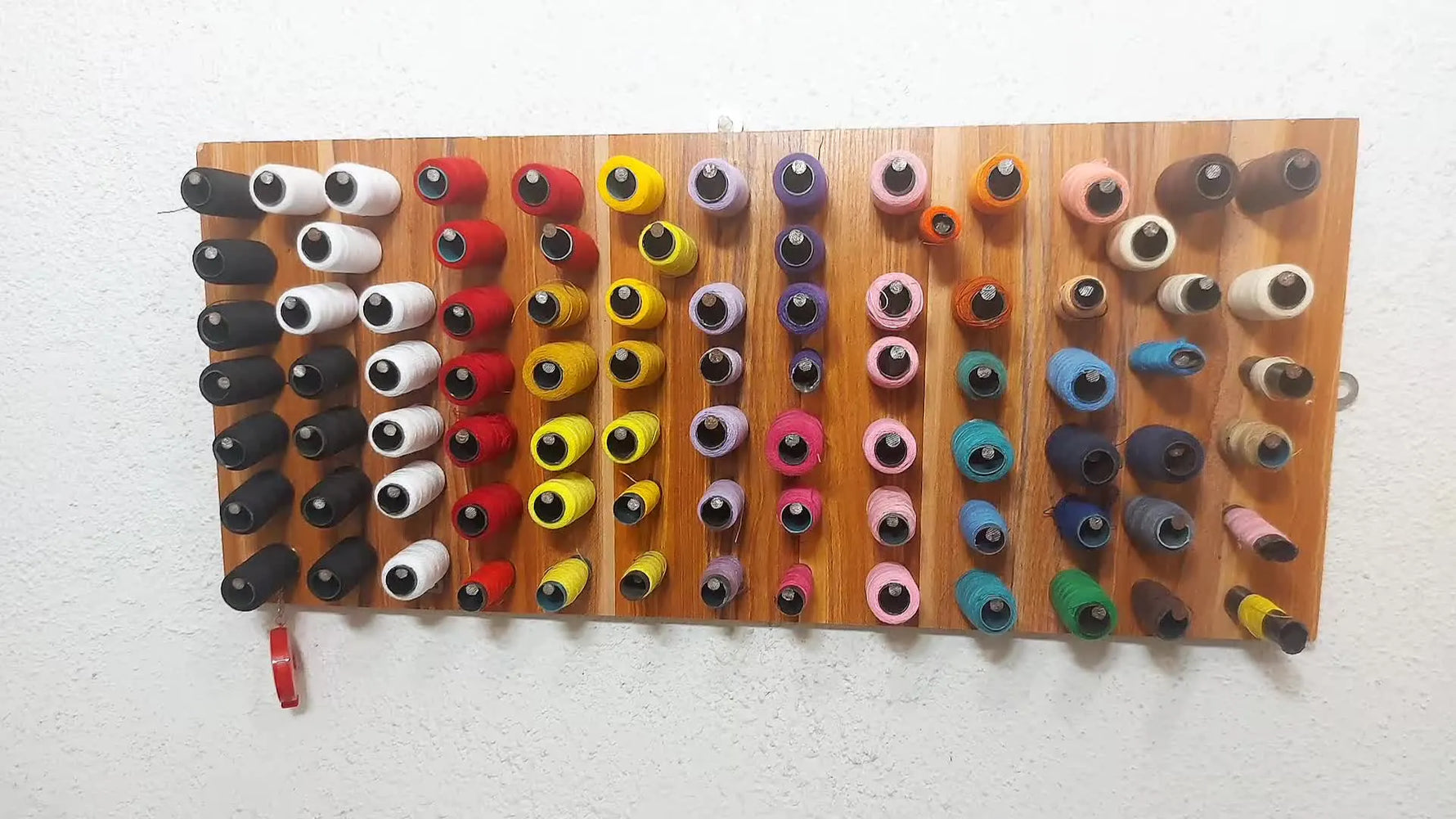 Wall-mounted thread rack with color-coded arrangement