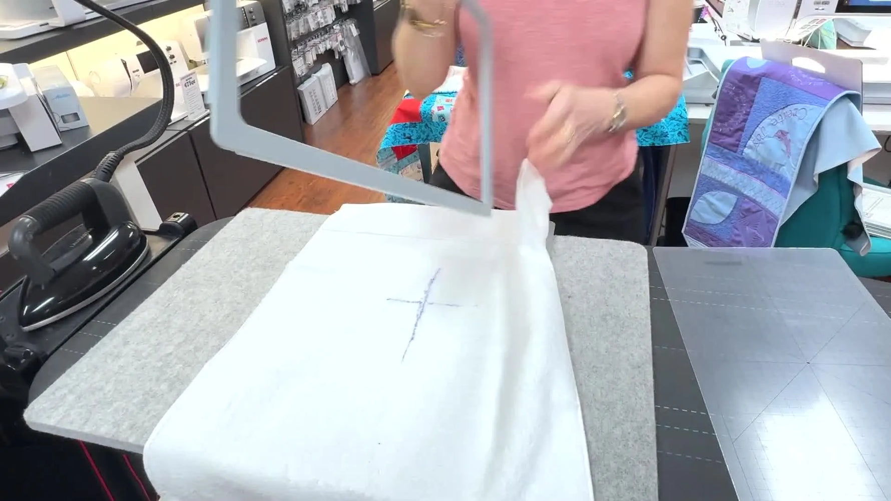 Hands align the top magnetic frame into the left handle slot on a hooped towel, showing the key “seat it first, then drop it” motion.